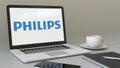 Opening laptop with Philips logo on the screen. Modern workplace conceptual editorial 4K clip