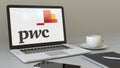 Opening laptop with PricewaterhouseCoopers PwC logo on the screen. Modern workplace conceptual editorial 4K clip