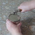 opening a metal can with a can opener