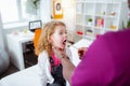 Cute curly girl opening mouth wide while visiting doctor Royalty Free Stock Photo