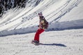 Opening of a ski resort, a young girl on a snowboard on a background of mountains Royalty Free Stock Photo