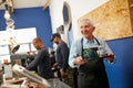 Opening a small business after retirement is so rewarding. a senior man working in a coffee shop. Royalty Free Stock Photo