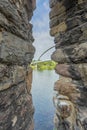 Opening between a stone wall of an old medieval wall with the Maas river, trees and the High Bridge in the background Royalty Free Stock Photo