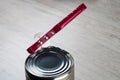 Opening a tin can with a can opener. The can opener is on the tin can Royalty Free Stock Photo