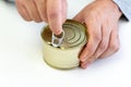 opening a tin can on a white background. Hand holds canned food on white, man hands. empty label for design and text Royalty Free Stock Photo