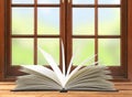 Openned book on wooden table and window and nature background
