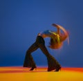 Openness. Portrait of young girl dancing heels dance in stylish clothes over blue background in neon with mixed lights Royalty Free Stock Photo