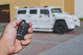 Opens Keys, keychain, in the hand of a man. Against the backdrop of a large car