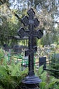 Openwork forged black metal cross close-up cemetery death