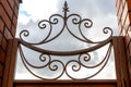 Openwork forged lattice on the fence. Against the background of the blue sky. Royalty Free Stock Photo