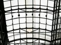 Openwork glazing of the roof over the shopping center. Ceiling in the form of a steel arch with glass windows. Bottom view on a cl Royalty Free Stock Photo