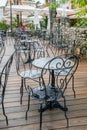 Openwork metal chairs and tables cafe wooden pavement street after the rain. Street cafe Porec, Croatia Royalty Free Stock Photo