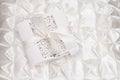 Openwork wedding invitation on a white satin background Royalty Free Stock Photo