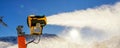 Operating artificial snow cannon near piste making snowy powder.Ski lift ropeway on hilghland alpine mountain winter resort on