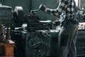 Operating machine. Factory male worker in uniform is indoors Royalty Free Stock Photo