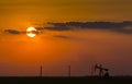 Operating oil and gas well profiled on sunset sky Royalty Free Stock Photo