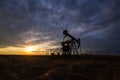 Operating oil and gas well and sunset sky