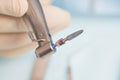 During the operation, the dentist holds implantation tools with a titanium implant