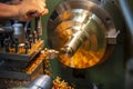 The operation of lathe machine cutting the brass shaft material.