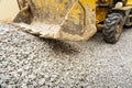 Operation of Wheel loader excavator for unloading crushed stone during the repair of city utilities and road works. Housing and Royalty Free Stock Photo