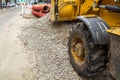 Operation of Wheel loader excavator for unloading crushed stone during the repair of city utilities and road works. Housing and Royalty Free Stock Photo