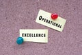 Operational excellence words on stick note and pinned to a cork notice board.
