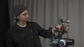 The operator adjusts a professional video camera standing on a tripod close up. Behind the scenes of filming video Royalty Free Stock Photo