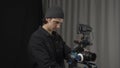 The operator adjusts a professional video camera standing on a tripod close up. Behind the scenes of filming video Royalty Free Stock Photo