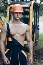Operator concept. Excavator operator on construction site. Muscular operator in working uniform. Machine operator with