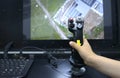 Operator hand holding a joystick control of the control panel station for an unmanned aerial vehicle, monitor