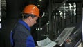 Operator monitors control panel of production line. Manufacture of plastic water pipes factory. Process of making