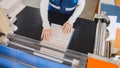 The operator of printing production pulls a printed sheet of paper