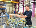 Operator repairs a machine in an industrial plant with tools - p