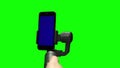 Operator`s hand controlling steadicam with blue screen on smartphone upright.