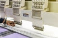 Operator or tailor working on modern and automatic high technology sewing machine for textile or clothing apparel making