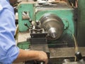 Operator turning mold parts by manual lathe
