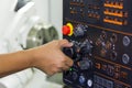 Operator use hand turns dial switch control at panel for adjust parameter of cnc lathe machine at factory Royalty Free Stock Photo
