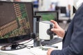 Operator working on digital microscope, inspecting electronic component Royalty Free Stock Photo