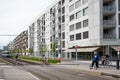 Opfikon, Switzerland - April 19th 2020: Cyclists crossing tramline in front of the modern facades of Glattpark