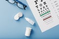 Ophthalmic Accessories Glasses and lenses with an Eye Test Chart for vision correction on a blue background Royalty Free Stock Photo