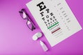 Ophthalmic accessories Glasses and lenses with vision test table for vision correction on a pink background Royalty Free Stock Photo