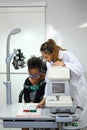 Ophthalmologist checking child eyesight with ophthalmology measurements letters, for testing visual acuity