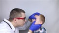 An ophthalmologist examines a boy who complains of burning and pain in his eyes. Eye fatigue from a computer or phone screen sens