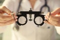 Ophthalmologist holds special ophthalmic glasses for checking vision close-up.