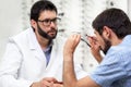 Ophthalmologist offering eyeglasses for a try out. Optometrist offering to wear a pair of glasses.