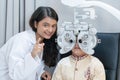 Ophthalmologist or optometrist or doctor doing eyes vision exam test for Indian child boy in traditional clothes with diagnostic