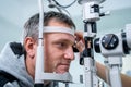 Ophthalmologist and patient testing eyesight. Man doing eye test with optometrist. Ophthalmologist using apparatus for Royalty Free Stock Photo