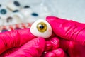 Ophthalmologist or surgeon holds an eye, eyeball prosthesis in hands