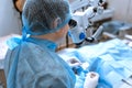 Ophthalmologist surgeon looking through surgical microscope doing difficult operation