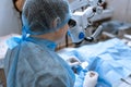 Ophthalmologist surgeon looking through surgical microscope doing difficult operation